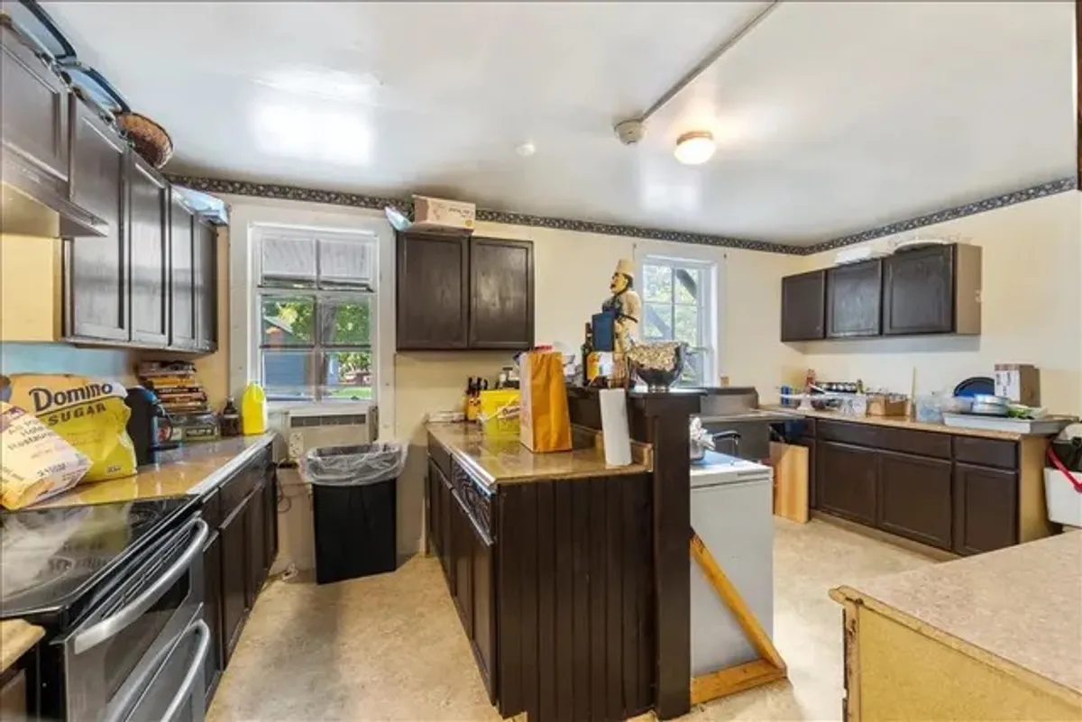 This image displays a kitchen island with dark wooden cabinets and countertop appliances, arranged in a way that feels both inviting and practical. The accessories and setup suggest that the kitchen is equipped for cooking, family gatherings, and meal preparation, while retaining an appealing balance of modernity and warmth.